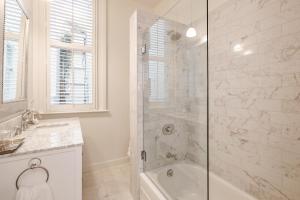 een witte badkamer met een douche en een bad bij Pacific Heights Victorian Bedroom and Bathroom in San Francisco