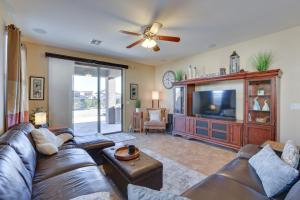 a living room with a couch and a flat screen tv at Goodyear Home with Patio - Near Estrella Mountain! in Liberty