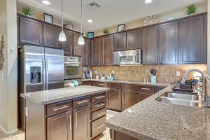 a kitchen with wooden cabinets and a stainless steel refrigerator at Goodyear Home with Patio - Near Estrella Mountain! in Liberty