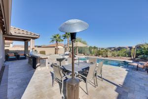 a patio with a table and chairs next to a pool at Goodyear Home with Patio - Near Estrella Mountain! in Liberty