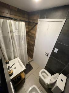 a small bathroom with a toilet and a sink at Apart Containers, Acantilados in Mar del Plata +19 photos