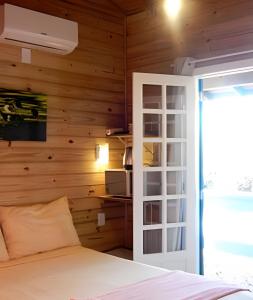 a bedroom with a wooden wall with a bed at Pouso do Guarani - 200m do mar|wifi|Ar cond in Florianópolis
