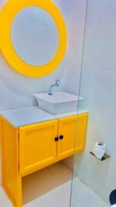 une salle de bains avec un lavabo jaune et un miroir dans l'établissement Casa de Praia Tutóia, à Tutóia 36 autres photos