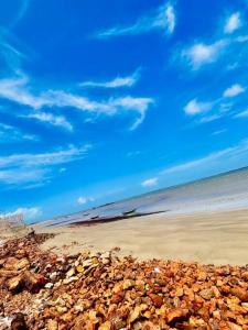 a beach with a bunch of rocks and a blue sky at Casa de Praia Tutóia in Tutóia