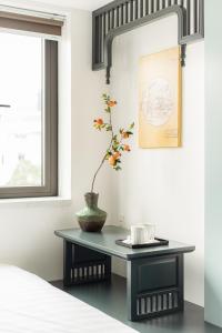 GARE D'47 Homestay/ Hotel في هاي فونج: طاولة عليها نبات في غرفة النوم