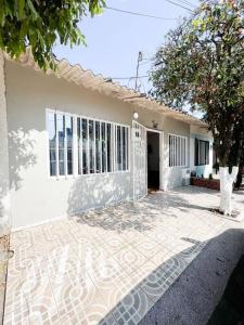 ein weißes Haus mit einem Baum davor in der Unterkunft Moderna Casa Familiar in Yopal