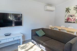 uma sala de estar com um sofá e uma mesa em Ingenia Holidays Noosa em Tewantin
