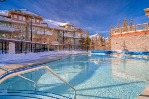 a large swimming pool in front of a building at Mountain Escape sleeps 10 Guests in this 3BD 2BT Top Floor Condo with Mountain View in Canmore