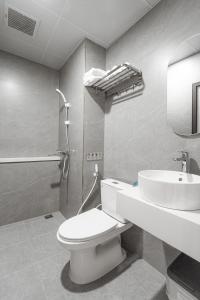 ein Bad mit einem WC, einem Waschbecken und einer Dusche in der Unterkunft GARE D'47 Homestay/ Hotel in Haiphong