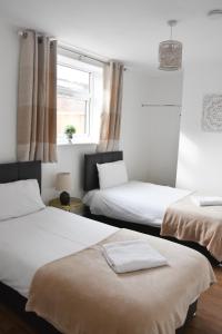 a room with two beds and a window at Parkside Apartment in Norwich