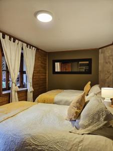 a bedroom with two beds and two windows at Hotel Boutique Terra Diaguita & Spa in La Serena