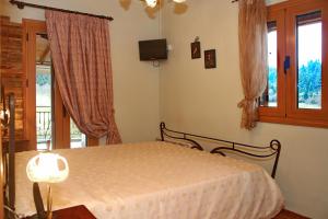 1 dormitorio con cama y ventana en Ktima Karadimou, en Karkaloú