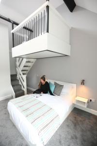 a woman sitting on a bed under a staircase at Moran's Bar & B&B in Grange