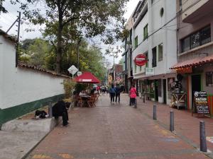 a cobblestone street with people walking down the street at Hotel Primitivo Usaquén in Bogotá