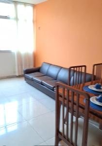ein Wohnzimmer mit einem Sofa und einem Tisch in der Unterkunft Apartamento grande Vitória in Vitória