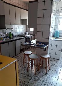 una cocina con dos mesas y taburetes. en Apartamento grande Vitória, en Vitória