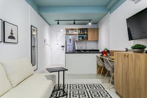 sala de estar y cocina con sofá y mesa en ARE - apartamentos próximos ao centro, en Florianópolis