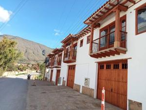 een wit gebouw met houten deuren en een straat bij Apartamento de la Villa I in Villa de Leyva