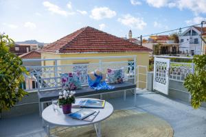 a balcony with a bench and a table at Boutique Villa Aspasia in Lixouri