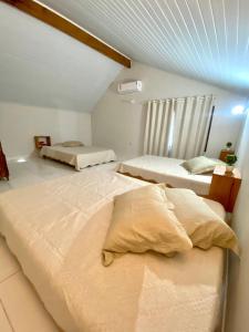a bedroom with two beds and a ceiling at Chalé Oxente em Corumbau-BA in Corumbau