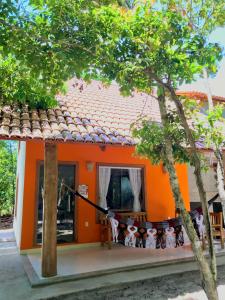 une maison orange avec un toit orange et une fenêtre dans l'établissement Chalé Oxente em Corumbau-BA, à Corumbau