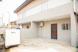a white building with a door in front of it at Plot 100 in Lagos