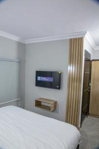 1 dormitorio con 1 cama y TV de pantalla plana en Plot 100, en Lagos