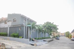 a street with a white building and palm trees at MORADA HOTELS LTD in Lagos