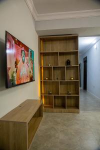 Plot 100 في لاغوس: غرفة معيشة مع طاولة ورف كتاب