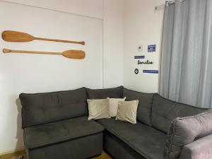 ein Wohnzimmer mit einem Sofa und hölzernen Fledermäusen an der Wand in der Unterkunft Centro Guarapari - espaço & conforto - WI-FI in Guarapari