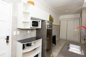 a kitchen with a stainless steel refrigerator and a microwave at Carnaval! Apt. moderno no Porto da Barra in Salvador