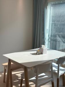 Biały stół z dwoma białymi krzesłami i oknem w obiekcie Clean 2 SuperSingle Beds House w Seulu