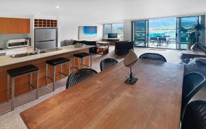 a kitchen and living room with a wooden table and chairs at Golfclub Townhouse Apollo Blue 7 in Apollo Bay