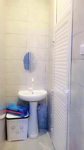 a white bathroom with a sink and a mirror at F&D villas in Dar es Salaam
