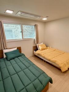 a bedroom with two beds and a window at Clean 2 SuperSingle Beds House in Seoul