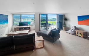 a living room with a couch and a tv and a table at Golfclub Townhouse Apollo Blue 7 in Apollo Bay