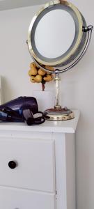 a mirror sitting on top of a white dresser at Loft Close to Downtown, Raymond James Stadium, Airport and Many More Places in Tampa