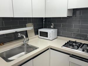 a kitchen with a sink and a microwave at Clean 2 SuperSingle Beds House in Seoul