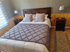 特木科的住宿－Hostal Callejón Massmann，一间卧室配有一张大床和木制床头板