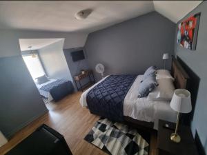 1 dormitorio con 1 cama extragrande y 1 silla en Hostal Callejón Massmann, en Temuco