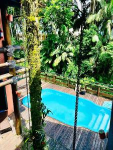 a swing around a pool in a garden at Casario 1915 Pousada in Morretes