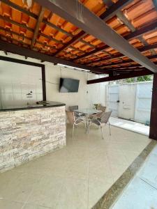 a patio with a table and chairs and a tv at Hospedagem Caminho das Praias in Niterói