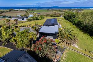 an aerial view of a house with solar panels on the roof at The Chocolate Box - Waipu Cove Holiday Home in Waipu