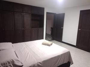 a bedroom with a large bed with wooden cabinets at La iguana café y más in Pereira