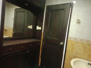 a bathroom with a black door and a sink and a mirror at La iguana café y más in Pereira