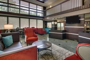 um átrio com uma sala de espera com cadeiras e uma televisão em Drury Inn & Suites Houston The Woodlands em The Woodlands