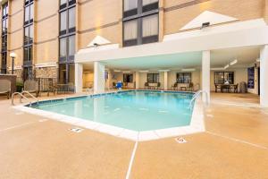 een zwembad in een hotel met tafels en stoelen bij Drury Inn & Suites Houston Sugar Land in Sugar Land