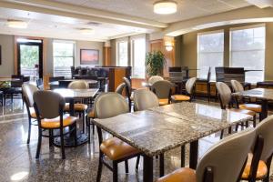 uma sala de jantar com mesas, cadeiras e janelas em Drury Inn & Suites San Antonio North Stone Oak em San Antonio