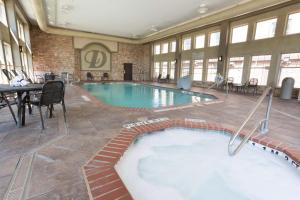 a large swimming pool in a building with a table and chairs at Drury Inn & Suites San Antonio North Stone Oak in San Antonio