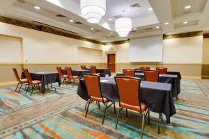 una sala conferenze con tavoli, sedie e un podio di Drury Inn & Suites Greenville a Greenville